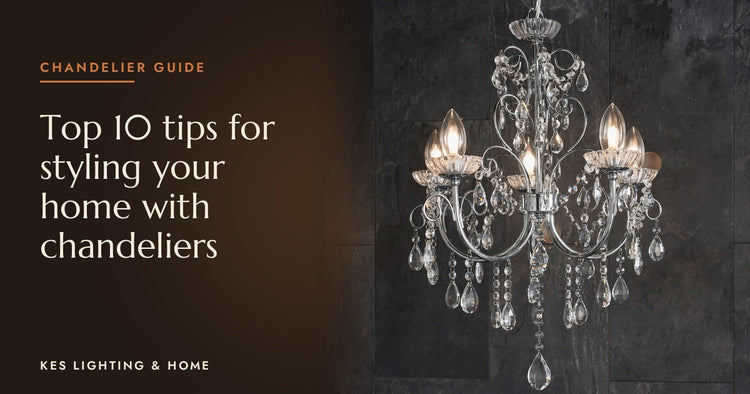Chandelier with clear drops and candle bulbs against a dark wall