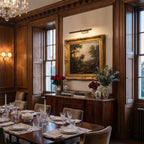 Astro Renoir 680 LED Picture Light in Bronze shown lit in a dining room