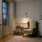 Astro Fosso Switched Reading Light in Bronze lit beside an armchair in a panelled Georgian sitting room