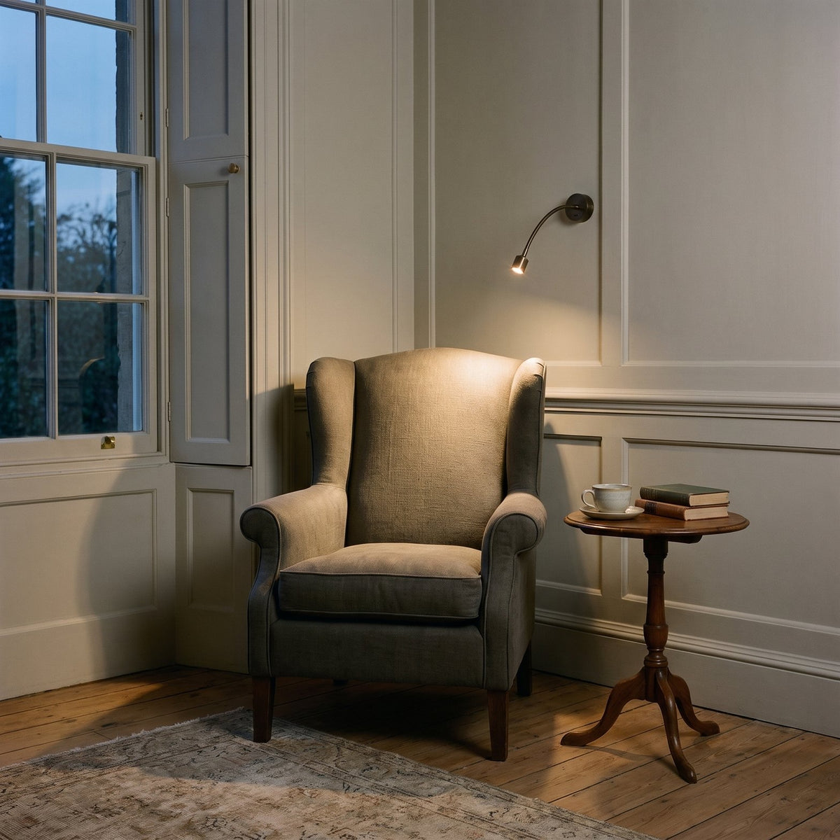Astro Fosso Switched Reading Light in Bronze lit beside an armchair in a panelled Georgian sitting room