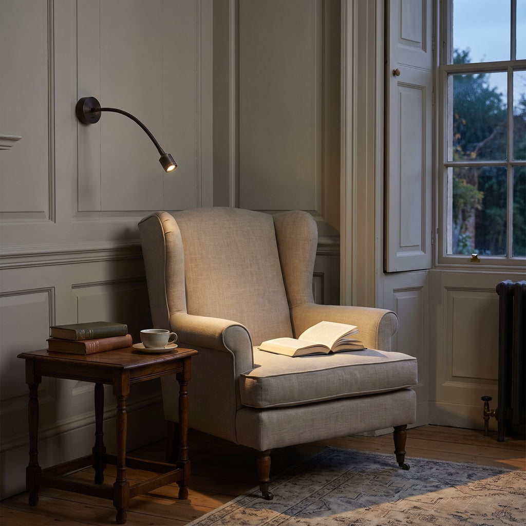 Astro Fosso Switched Reading Light in Bronze lit beside an armchair in a panelled Georgian sitting room