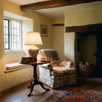 Elstead Arum Lily Table Lamp in Green with Cream Shade lit in a beamed country cottage sitting room