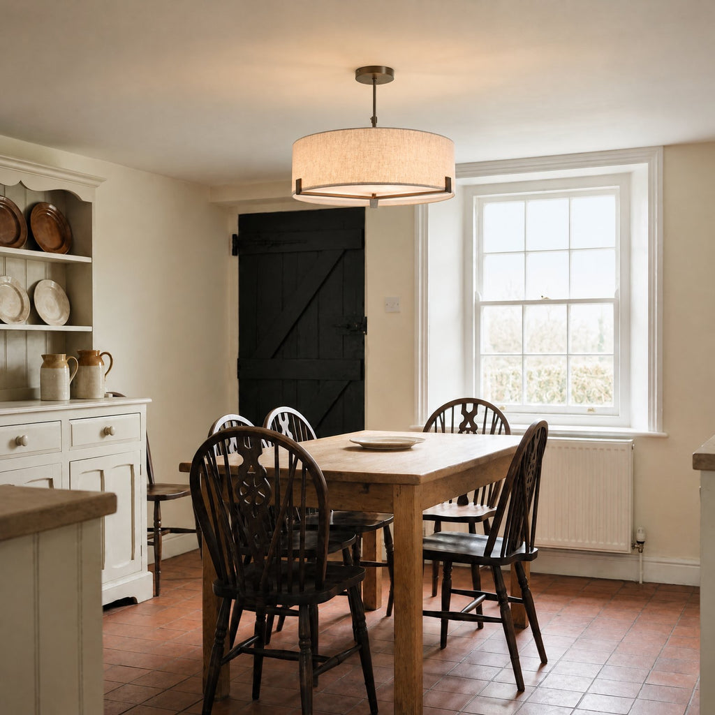 Endon Hayfield 3 Light Pendant in Brushed Bronze with Natural Linen lit over an oak table in a Victorian farmhouse kitchen-diner
