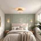 Marietta flush ceiling light in antique brass with a pair of Marietta wall lights above the bed, in a sage panelled bedroom