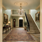 Feiss Valentina 12 Light Chandelier in Oxidised Bronze lit in a Georgian entrance hall with a stone staircase and gallery landing