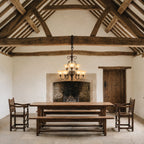 Hinkley Cello 9 Light Chandelier in Bronze lit over an oak refectory table in a beamed manor house hall