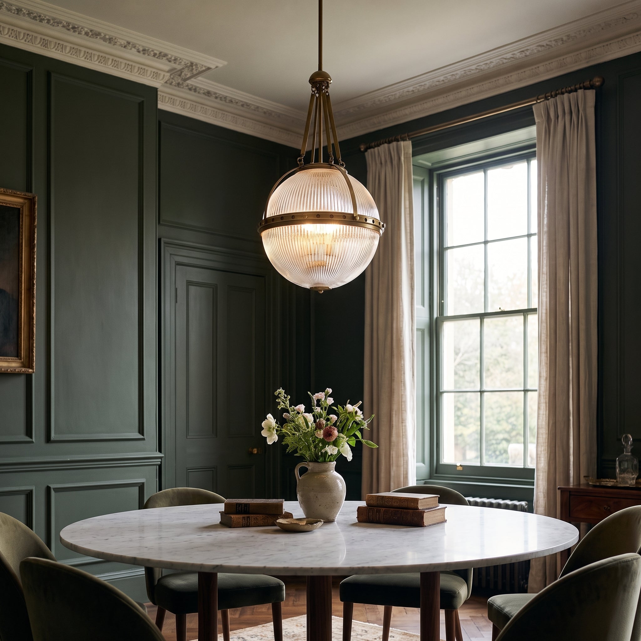 Kichler Aster 3 Light Pendant Light in Natural Brass, lit, in a styled room. Editorial image for the Brass and Gold Ceiling Lights collection.