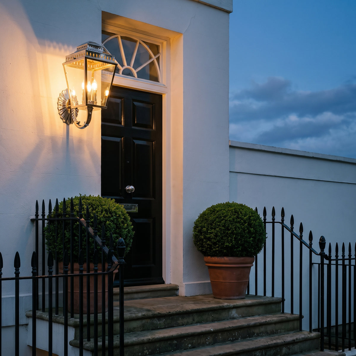 Elstead Mansion House 3 Light Coastal Wall Lantern in Polished Nickel, lit, in a styled room. Editorial image for the Chrome and Nickel Outdoor Wall Lights collection.