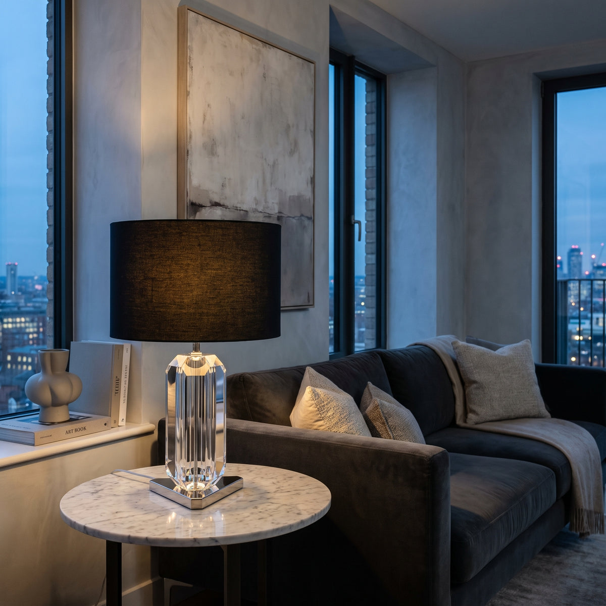 Eichholtz Emerald Table Lamp in Nickel Finish with Black Shade, lit, in a styled room. Editorial image for the Chrome and Nickel Table Lamps collection.