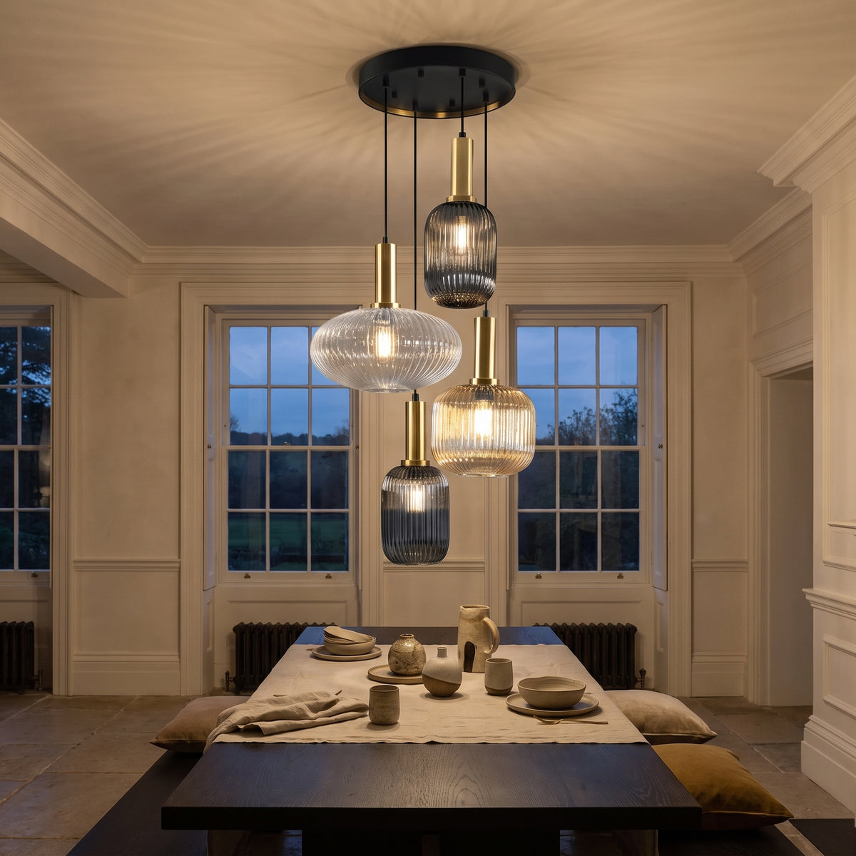 Schuller Norma 4 Light Pendant Light in Black and Brass, lit, in a styled room. Editorial image for the Matt Black Pendant Lights collection.