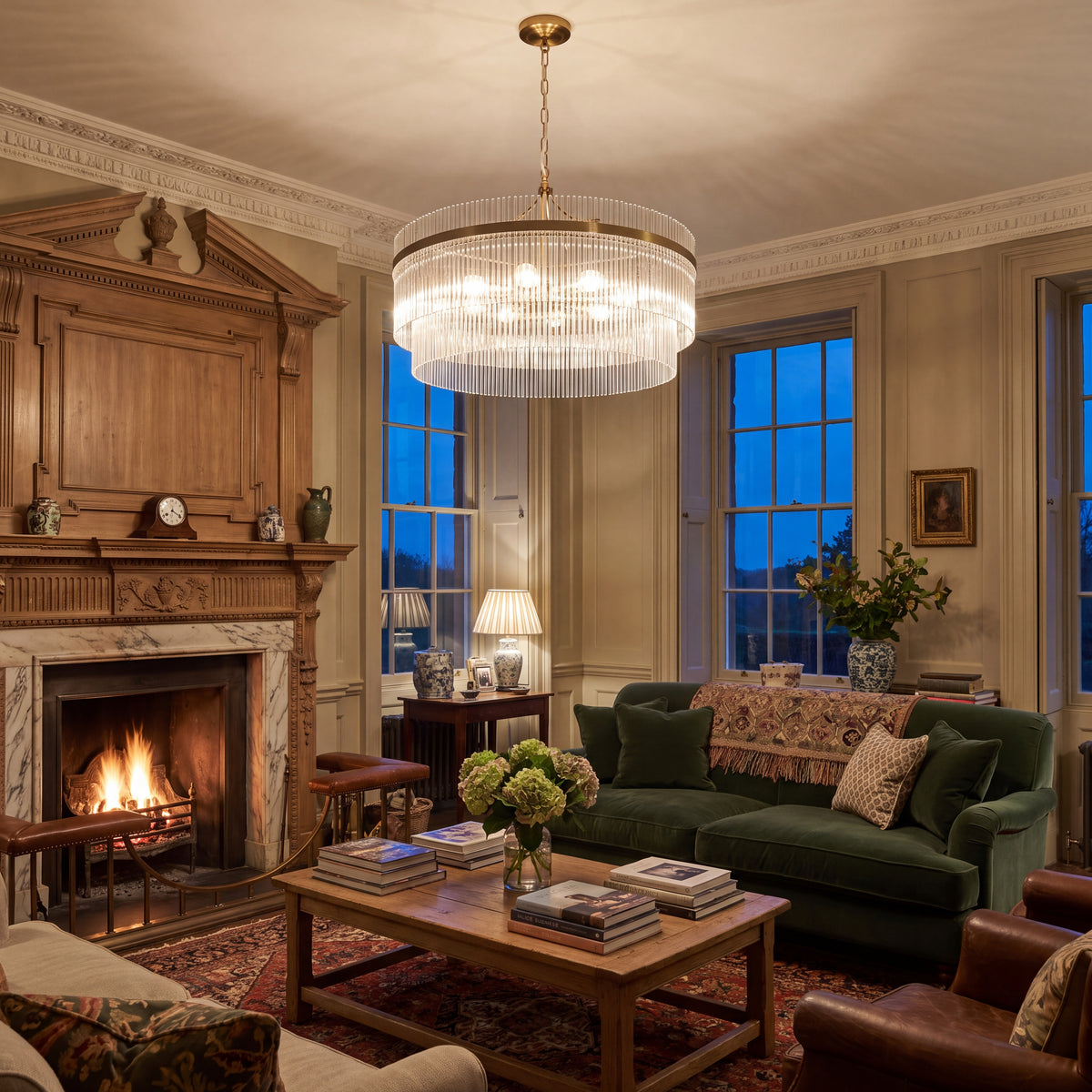 Endon Marietta Grand 7 light pendant in antique brass, lit at dusk in a period drawing room with a fire. KES homepage cover.