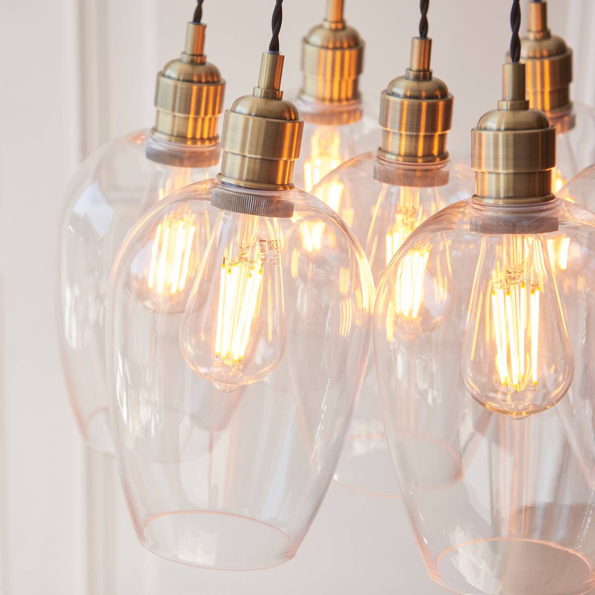 Novena Tarn 7 Light Cluster Pendant in Antique Brass with Clear Glass Shades